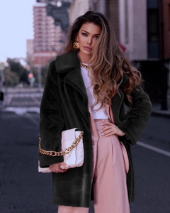 Detail of faux fur coat featuring oversized lapels and premium plush texture in dark green
