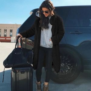 Women's black long faux fur teddy coat with lapel collar and pockets in outdoor street style