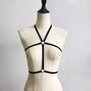 Detail of black elastic body harness featuring a central metal ring and strappy design