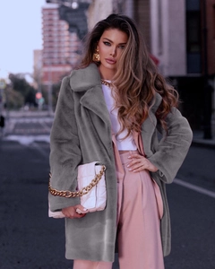 Detail of grey faux fur coat featuring a plush texture and wide lapel collar design
