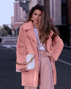 Detail of pink faux fur coat with oversized lapels and soft plush texture on woman
