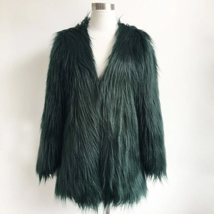 Dettaglio del cappotto in ecopelliccia verde smeraldo con trama morbida e design senza collo