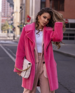 Detail of vivid pink faux fur coat featuring dense texture and stylish lapels for women