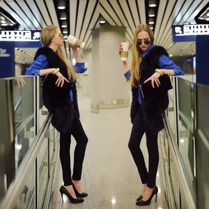 Gilet long en fausse fourrure noire pour femme avec chemise bleue et pantalon slim élégant