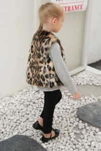 Détail montrant la texture de la fausse fourrure léopard sur un gilet enfant