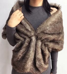 Close-up of fluffy grey-brown faux fur shawl with realistic fox fur texture on a model