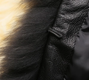 Detailed view of black leather jacket with lush faux fur collar and textured finish