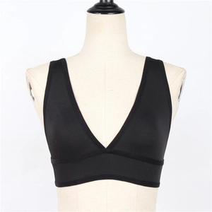 Détail d'un soutien-gorge de sport noir col en V avec large bande sur un mannequin beige