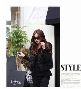 Detailed texture of fluffy black faux fox fur vest for women in a street style look