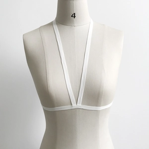Front view of white minimalist elastic body harness strap on a beige female mannequin