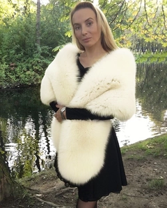 Close-up of soft white faux fur shawl wrap styled with a black dress in outdoor lighting