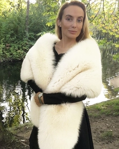 Detail of a large cream faux fox fur shawl wrap with fluffy long hair texture for winter