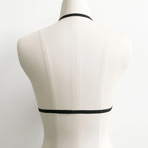 Detail view of the black elastic strappy bra back design with harness style straps