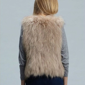 Back view of a women's tan faux fox fur vest with long plush hair and fluffy texture