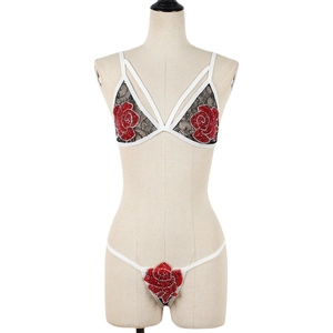 Lace lingerie set featuring black lace cups, white straps, and red sequin rose patches