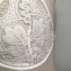 Détails de la dentelle florale délicate et du tulle transparent sur un soutien-gorge blanc