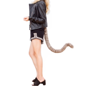 Faux fur animal tail accessory in brown and grey stripes with fluffy texture on model
