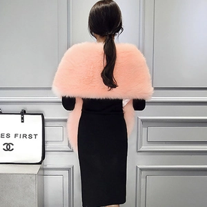 Back view of a soft pink faux fur shawl draped over a black dress for women
