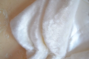 Gros plan d'une cape en fausse fourrure blanche avec texture douce et doublure satin