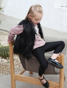 Detailansicht einer Kinder-Webpelzweste in Schwarz über einem bedruckten Sweatshirt