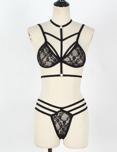 Detailansicht der sexy schwarzen Spitzenunterwäsche mit Riemchen-Harness und Blumenmuster