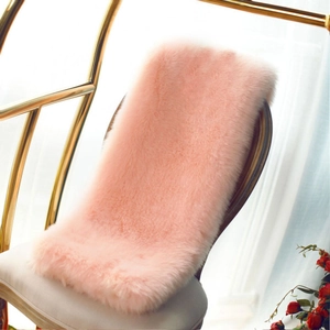 Detail of pink faux fur chair cushion with soft long hair texture on a metal chair
