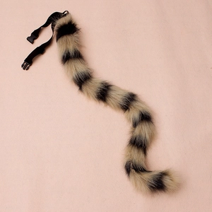 Detailed view of striped faux fur cat tail with adjustable nylon strap and plastic buckle