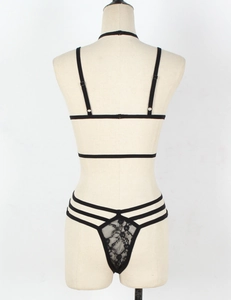 Detailansicht eines schwarzen Spitzen-Dessous-Sets mit elastischen Trägern an einer Puppe