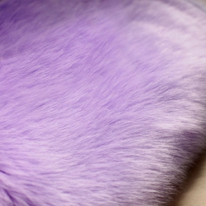 Macro shot of fluffy lavender faux fur fabric with dense and soft fiber texture