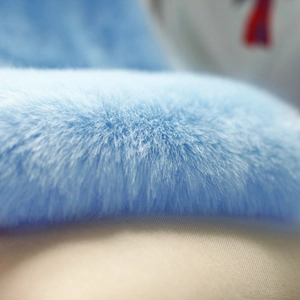 Close-up of soft light blue faux fur texture showing fluffy and dense plush fibers