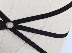 Detailansicht eines schwarzen elastischen Strappy-Harness mit zentralem O-Ring-Design