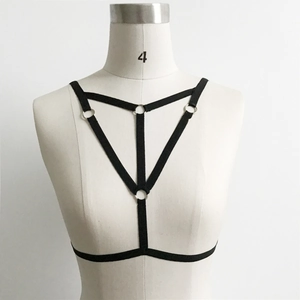 Detail of black elastic harness bra featuring geometric straps and silver metal rings
