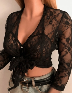 Détails de la texture dentelle florale sur un cardigan noir noué à manches longues
