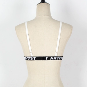 Detail of black elastic band with white Artist lettering on a lace bralette top