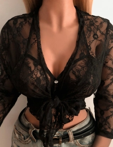 Détail du gilet en dentelle florale noire avec col en V profond et bouton en cristal