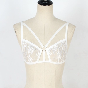 Detailed view of white floral lace bra featuring multi-strap cross design and central metal ring