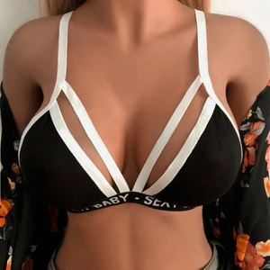 Detail eines schwarzen Sport-BHs mit weißen Trägern und elastischem Logoband