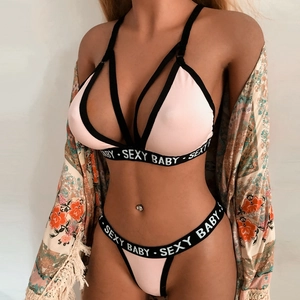 Detail of pink lingerie set with black straps and SEXY BABY lettered elastic band