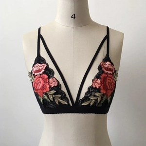 Detail of elegant black lace bra with vibrant red rose floral embroidery on cups