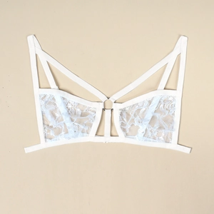 Detailed close-up of white floral lace bralette with sexy strappy design and metal ring