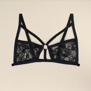 Detail of black floral lace lingerie top with crisscross straps and central metal ring
