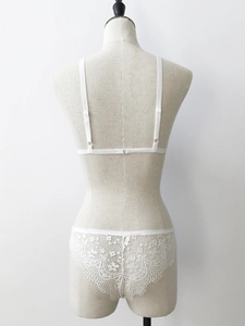 Detailed back view of white lace lingerie set with adjustable straps and scallop edges