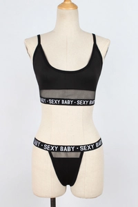 Detail view of black lingerie set with mesh panels and Sexy Baby elastic logo band