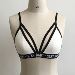 Détail des bretelles croisées et bande élastique avec texte SEXY BABY sur le soutien-gorge