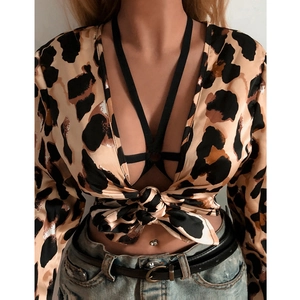 Sexy leopard print tie-front crop top with black strappy bralette and denim jeans