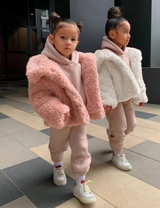Close-up of pink and white plush faux fur children jackets for winter fashion street style