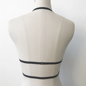 Detail view of black elastic lace strappy lingerie back with metal closure on mannequin