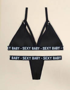 Detailed flat lay of black two-piece lingerie set featuring white lettered elastic bands