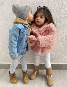 Close-up of children's pink faux fur coat and denim jacket for autumn winter style
