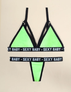Detail of neon green lingerie set with black SEXY BABY elastic lettered bands